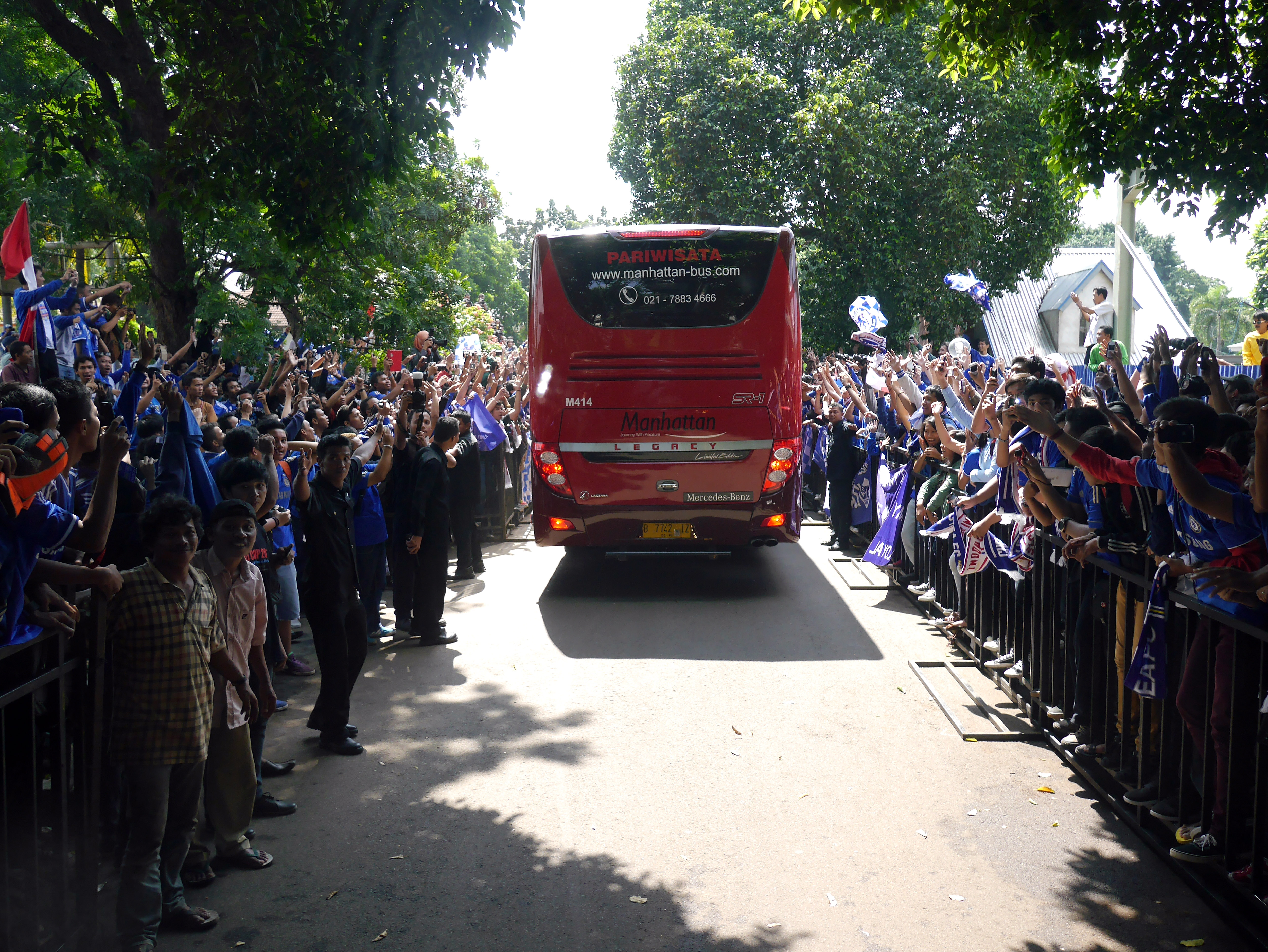 Thousands of Chelsea fans shown either side of the road as the Chelsea team coach passes by as it exits the airport in Jakarta.