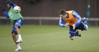  John Terry fires a header past team mate Ashley Cole during training  
