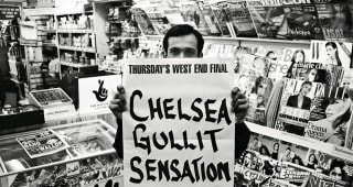 FULHAM ROAD, Feb 1998. The newsagent opposite Stamford Bridge prepapres to post up the day's headline about Chelsea manager Ruud Gullit. 