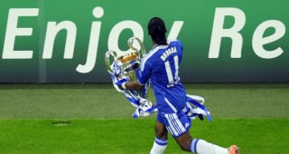 Didier Drogba runs with the trophy after the UEFA Champions League final football match between FC Bayern Munich and Chelsea FC on May 19, 2012 at the Fussball Arena stadium in Munich. Chelsea beat Bayern Munich 4-3 on penalties to win the Champions League. 