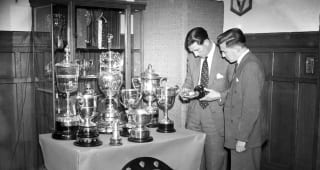 Sunday Chelsea manager Ted Drake (left) with the club's programme editor Albert Sewell looking at trophies in the boardroom at Stamford Bridge in 21st June 1955.