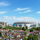 A view from a distance of Wembley Stadium with the arch clearly visible in front of a blue sky.