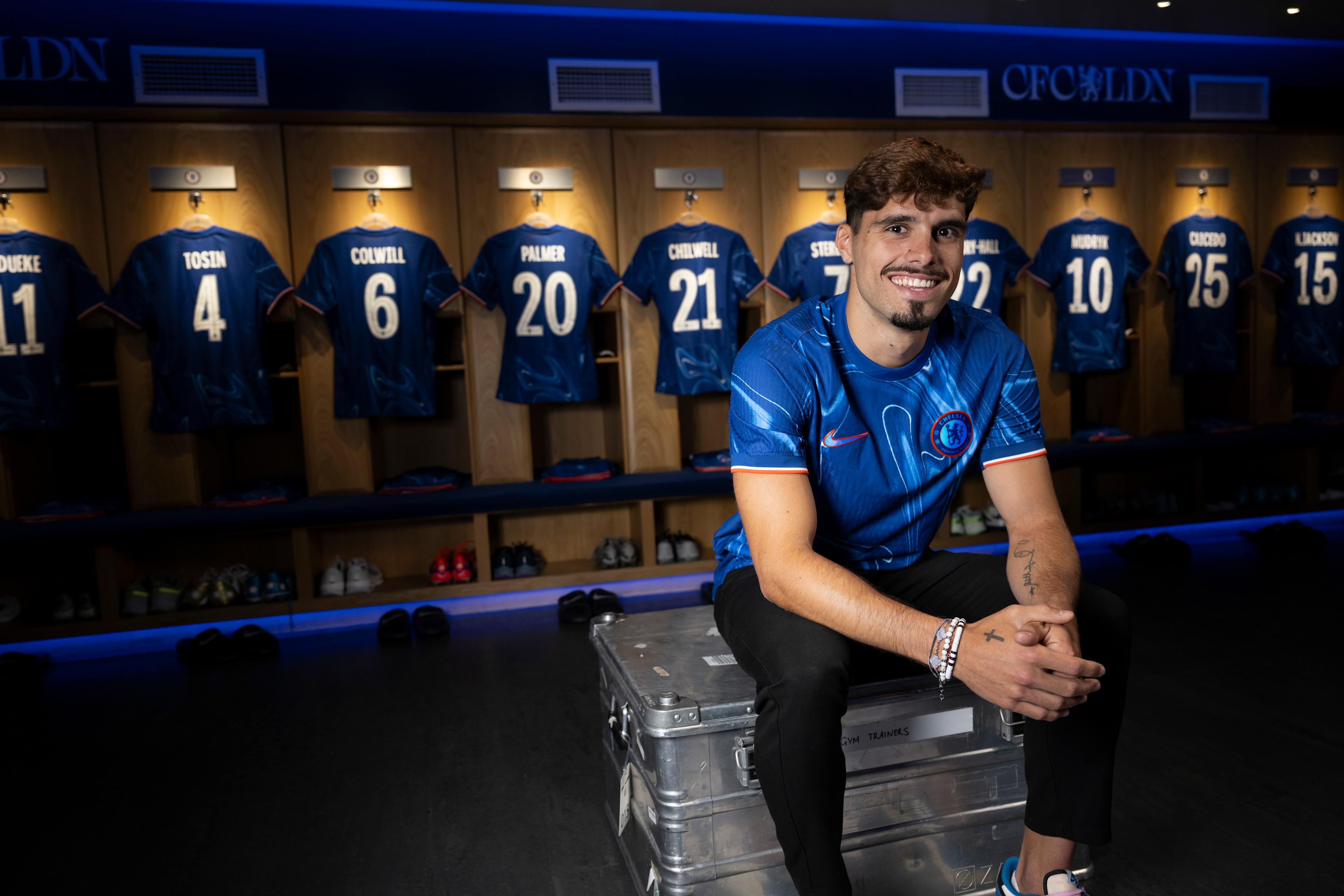 Pedro Neto poses in a Chelsea shirt after signing for the club in August 2024