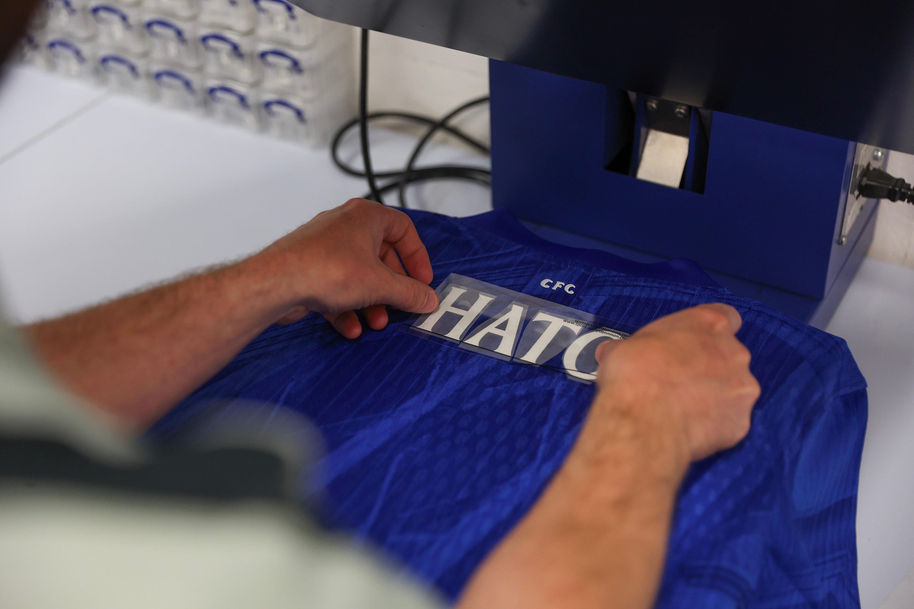 Jorrel Hato watches his name and number being printed on a Chelsea shirt