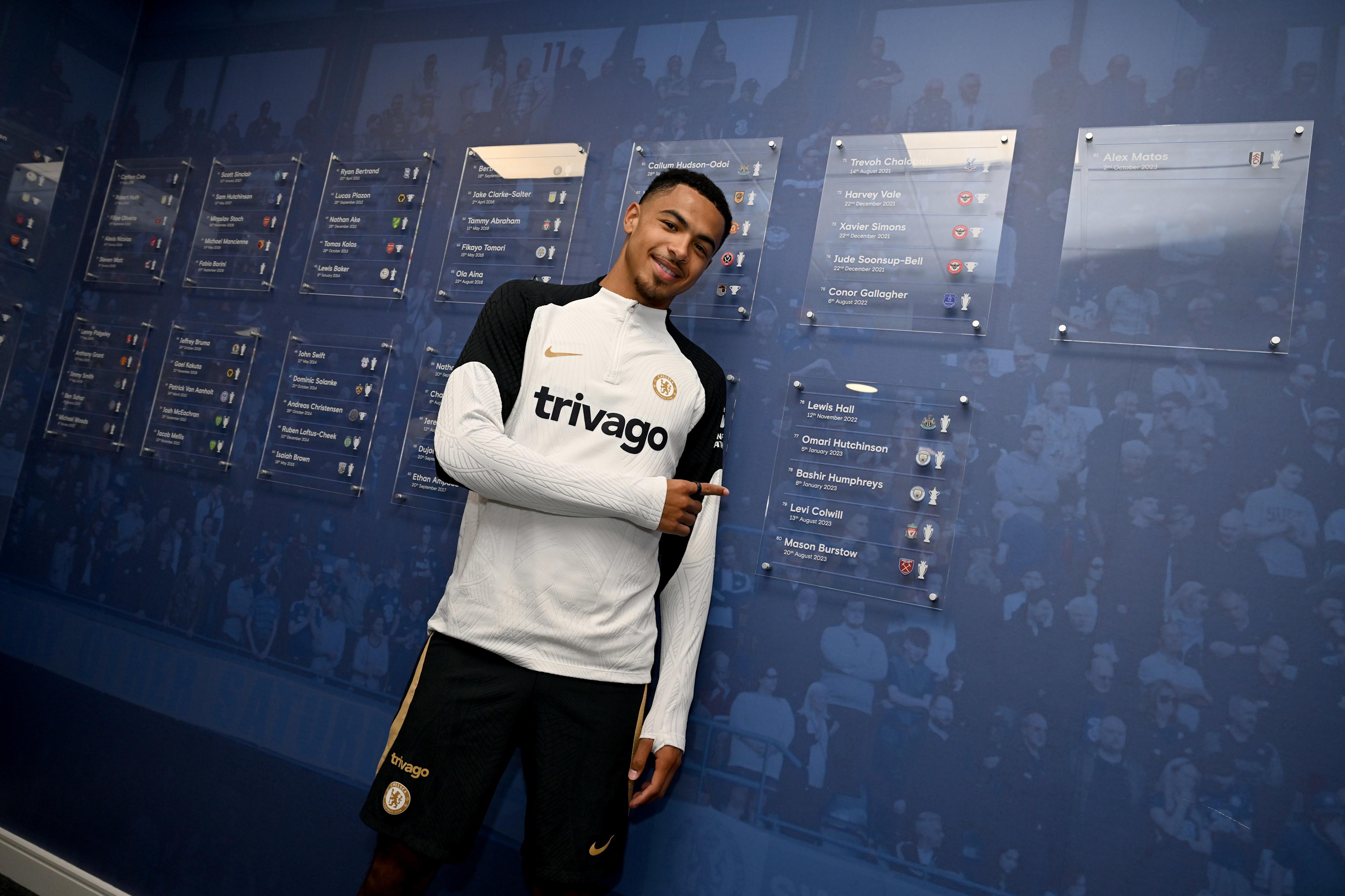 Levi Colwill stands beside his photograph on the Chelsea Academy wall at Cobham