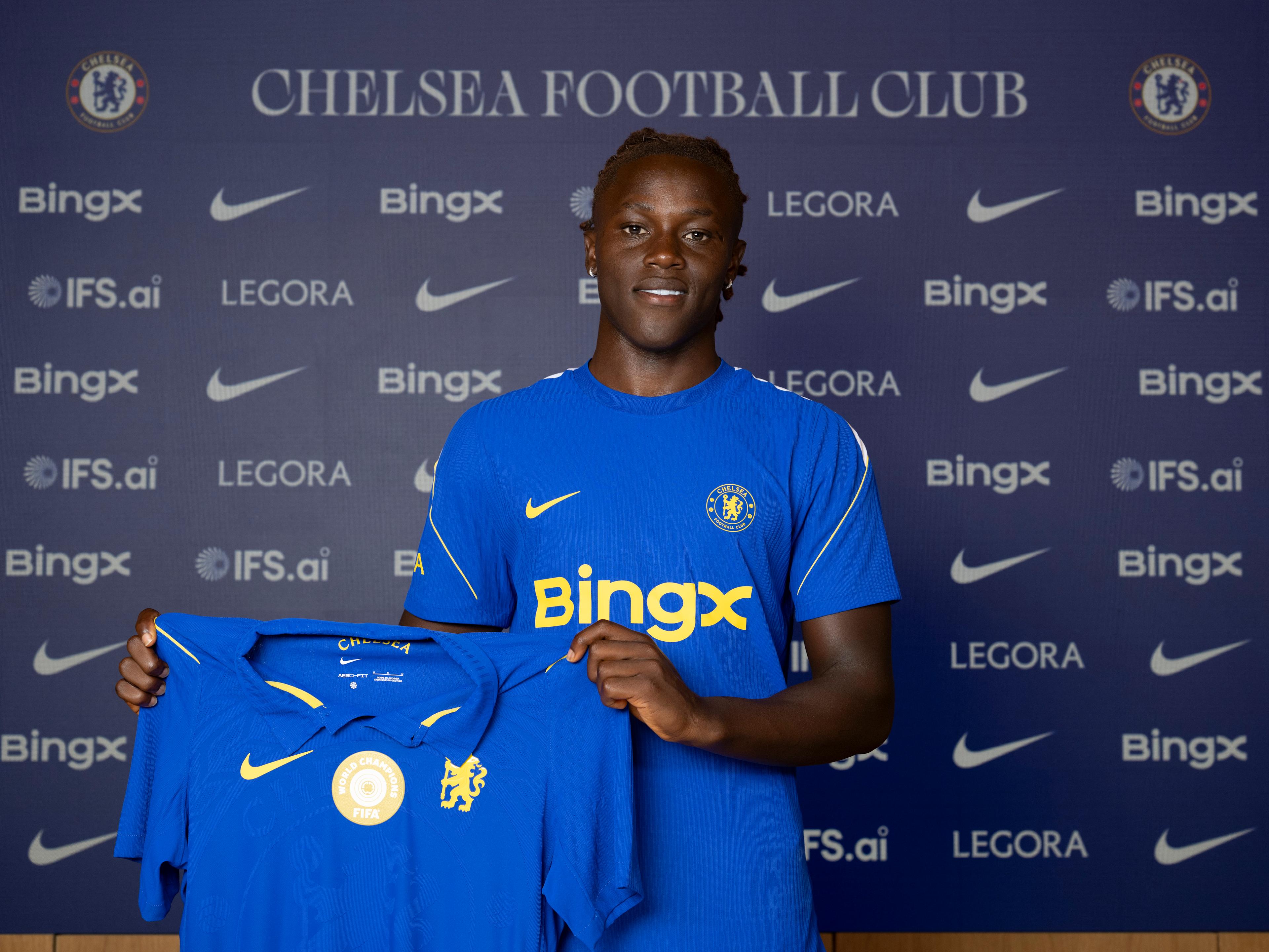 Geovany Quenda holds a Chelsea shirt during his Cobham arrival shoot