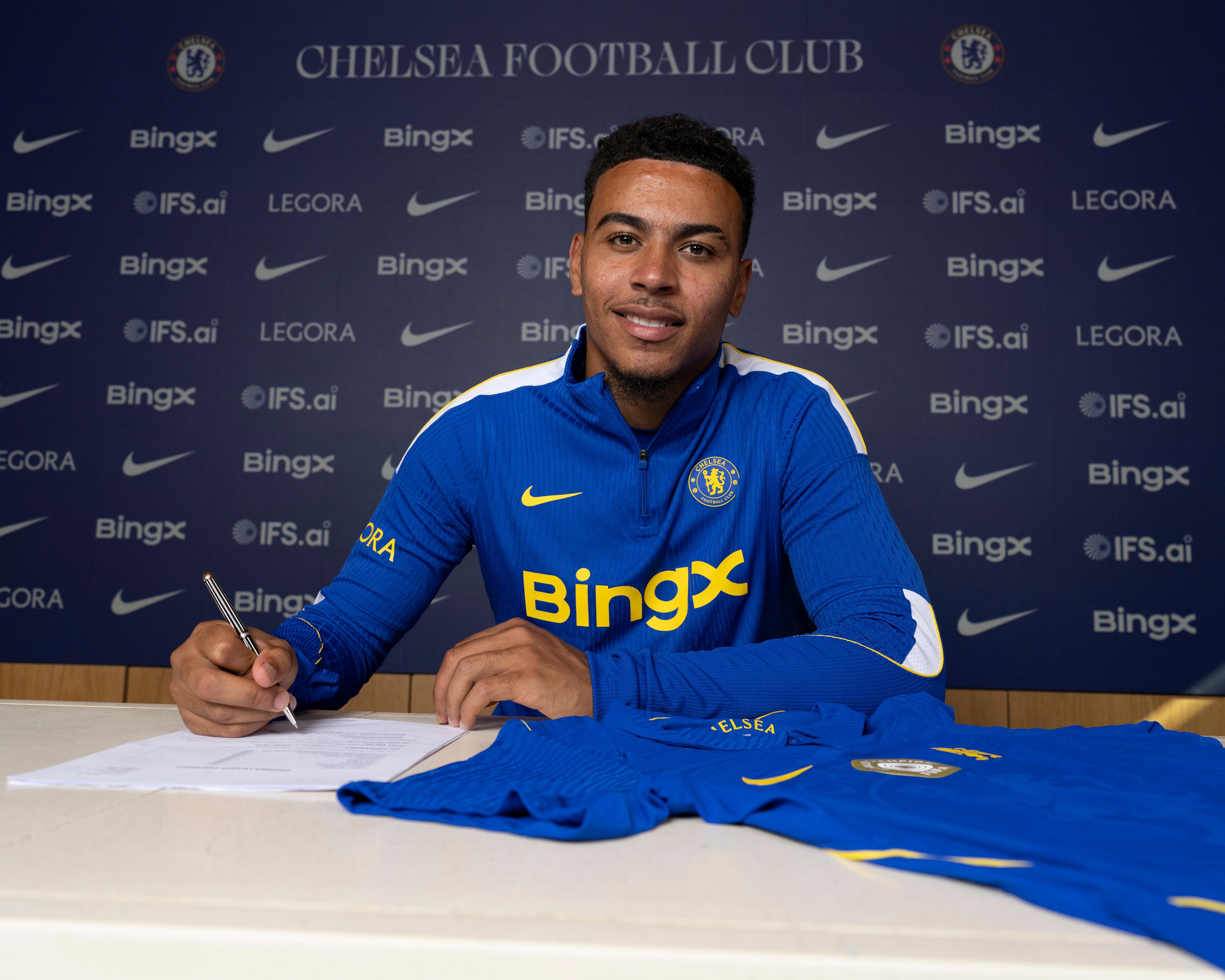 Morgan Rogers poses in a Chelsea shirt after signing for the club in July 2026