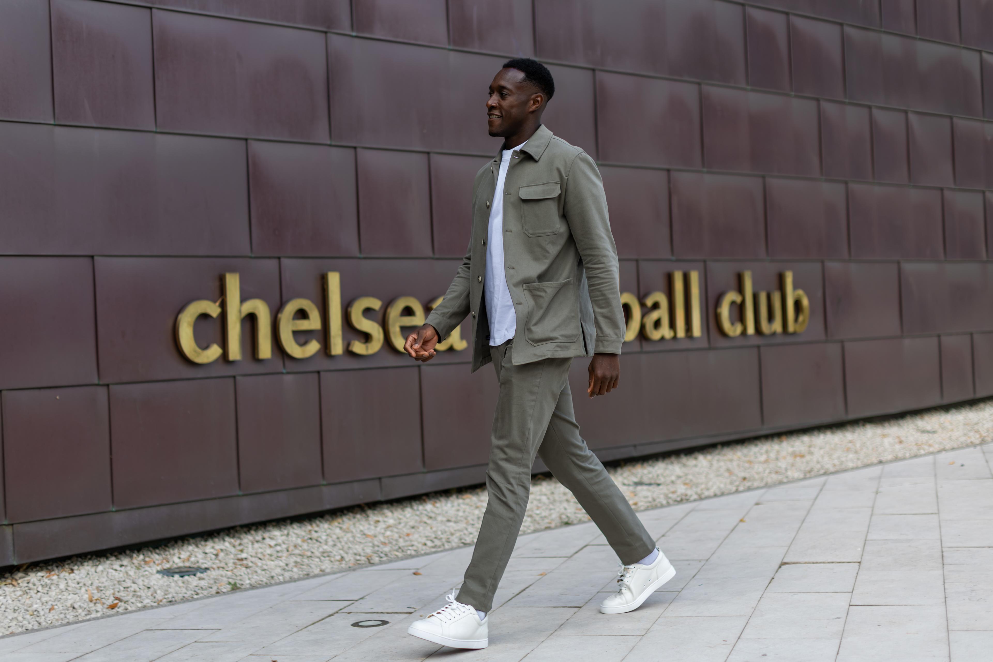Danny Welbeck walks past a Chelsea Football Club sign at Cobham