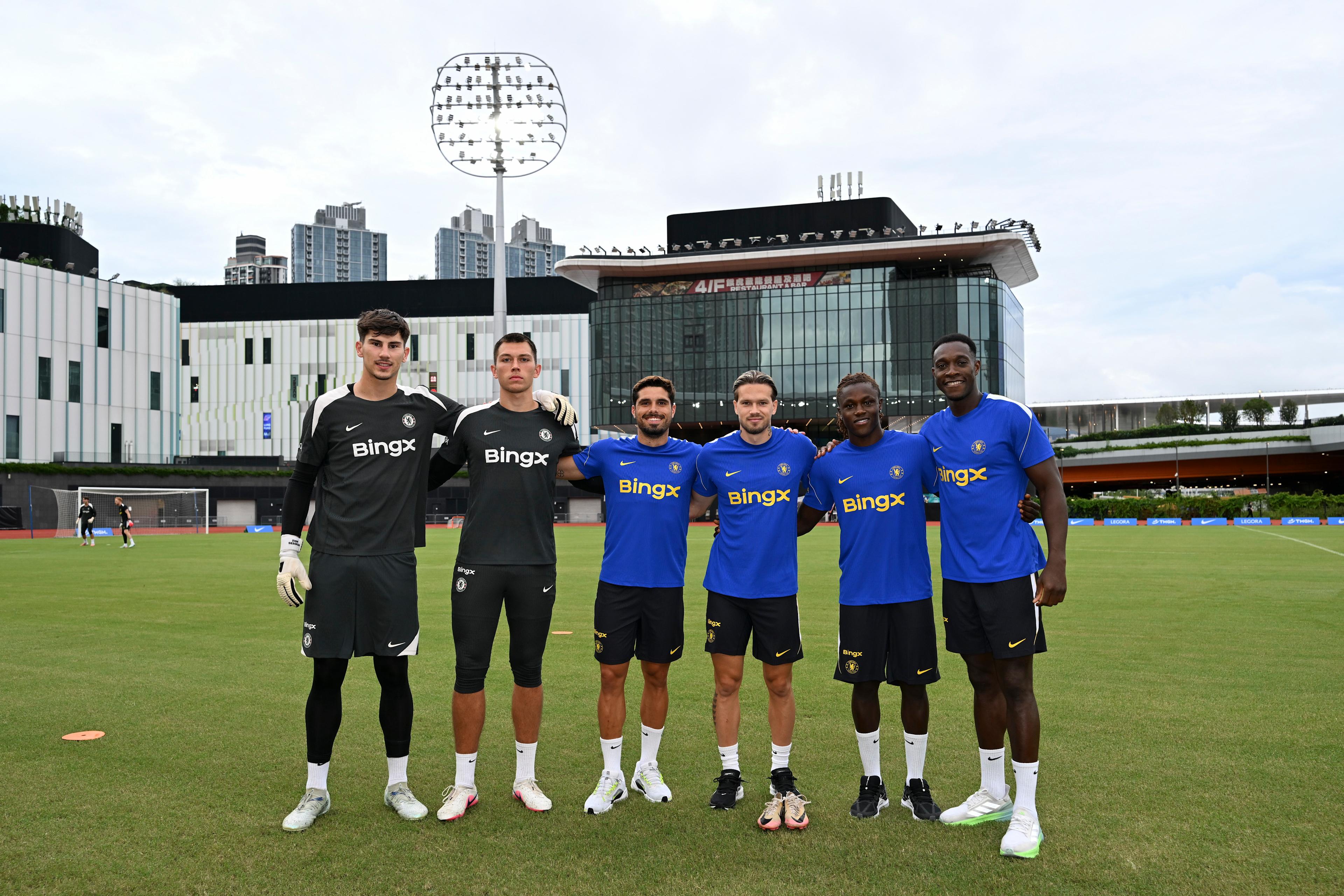 Mike Penders poses with Chelsea's new tour arrivals on the training pitch in Hong Kong