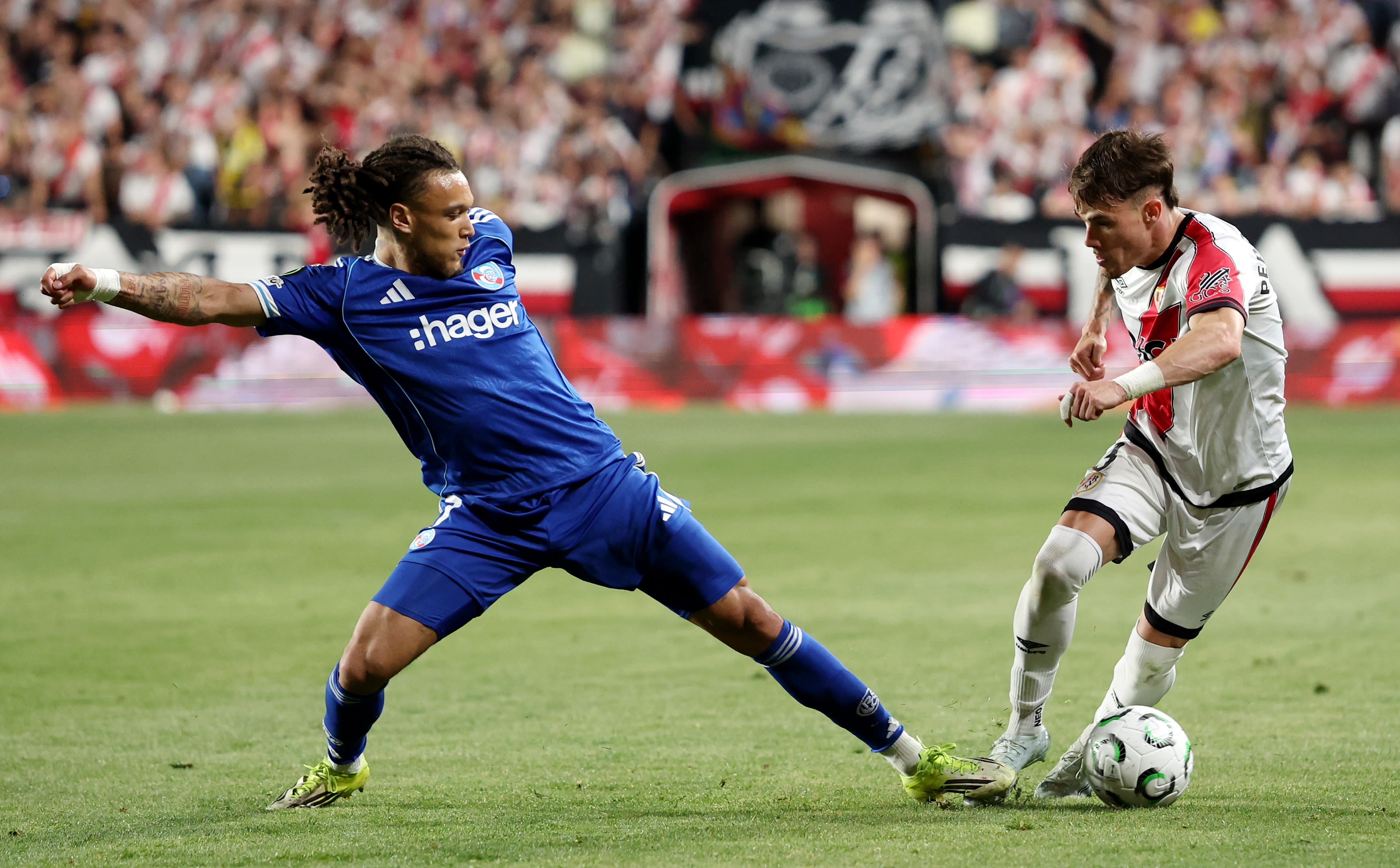 Pep Chavarría carries the ball past Diego Moreira in European competition
