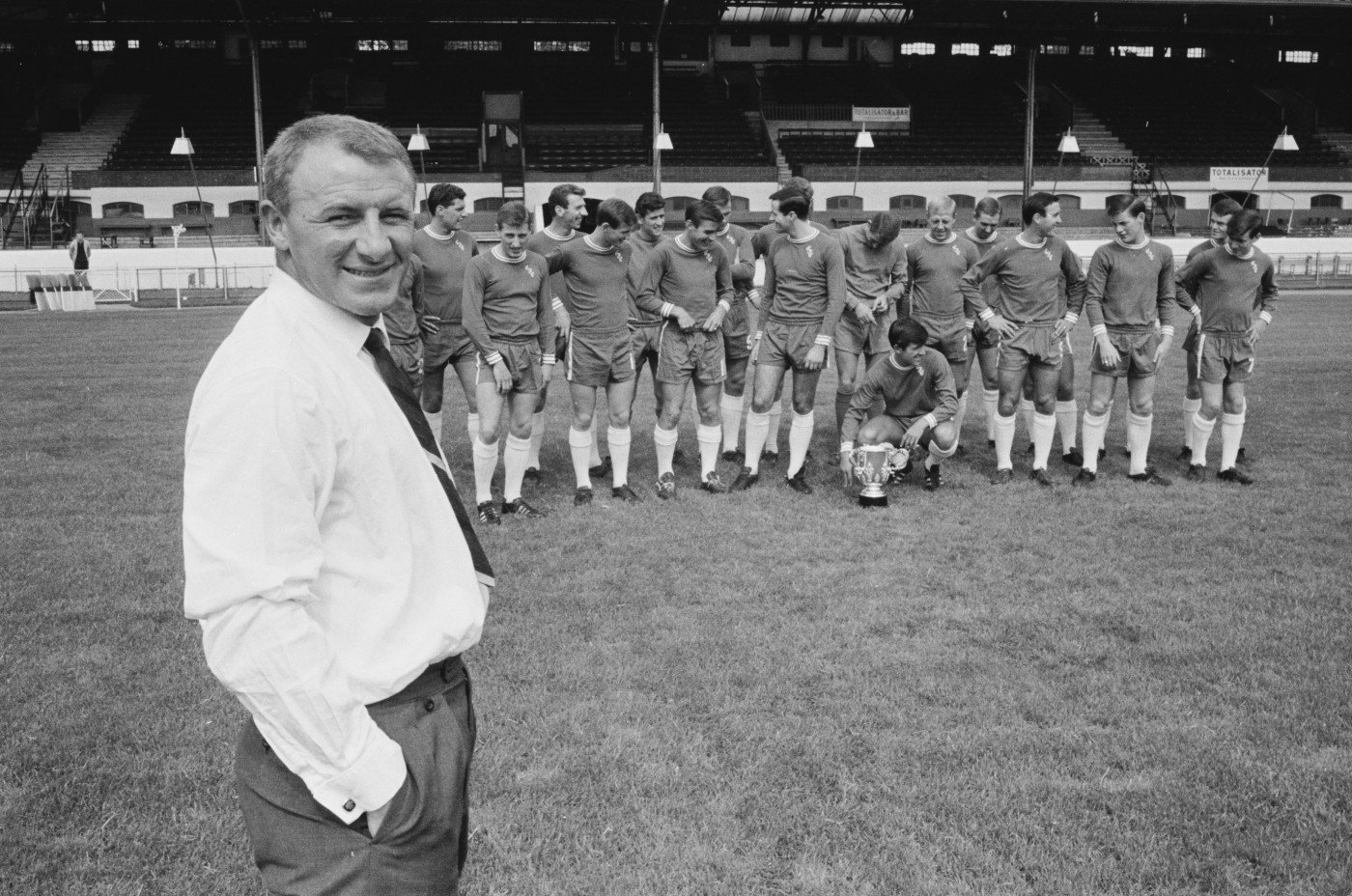 Manager Tommy Docherty poses proudly in front of his League Cup winners