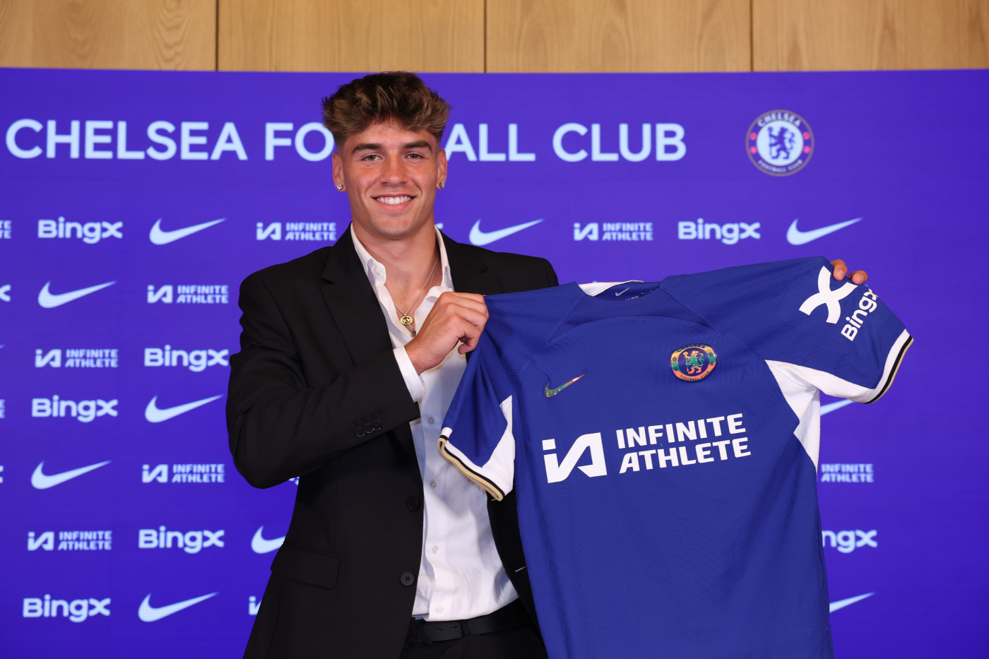 Marc Guiu holds up Chelsea shirt after joining the club.